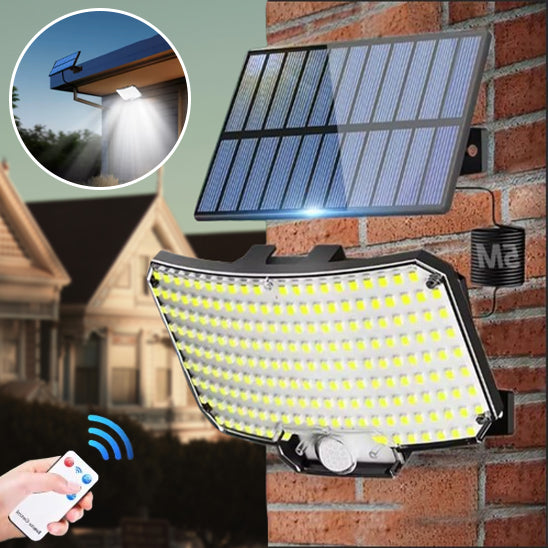 Lampe solaire extérieur avec panneau solaire de 234 led posée sur mur briques rouges, main tenant télécommande