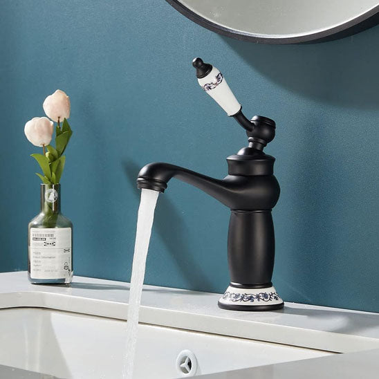 Robinet salle de bain noir antique eau limpide coule dans lavabo blanc ,deux roses dans bouteille ,mur bleu