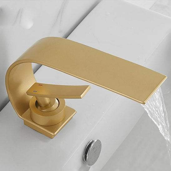 Robinet salle de bain or brossé coule dans le lavabo blanc