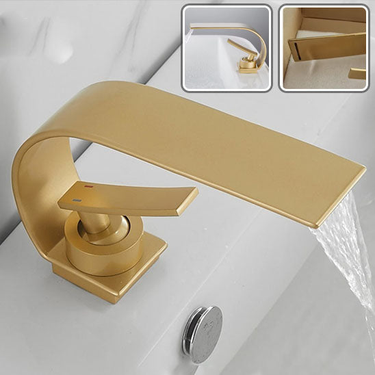 Robinet salle de bain or brossé coule dans le lavabo blanc d'eau limpide