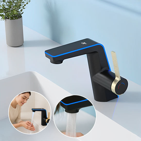 trois Mitigeur lavabo noir à poignee dorée et led bleue, bouquet fleurs sur évier et femme lave mains sous mitigeur lavabo