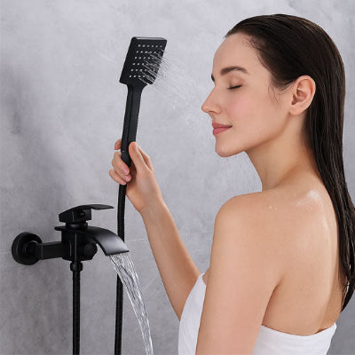 femme sous la douche tenant douchette de Mitigeur baignoire