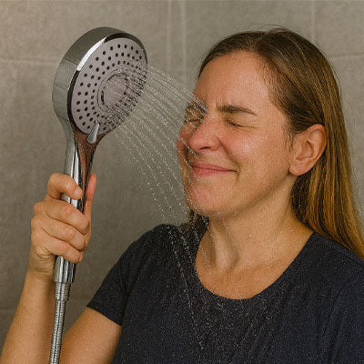 femme tient Pommeau de douche en mode pluie