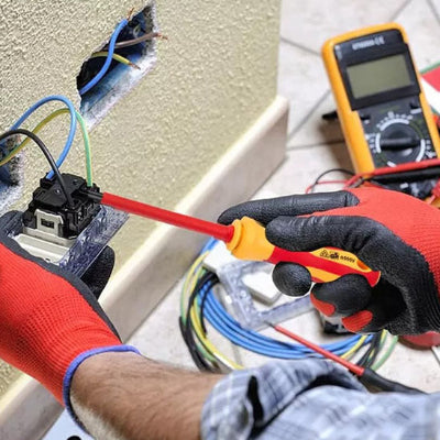 homme avec gants oranges répare transfo avec TOURNEVIS ELECTRICIEN, isolé avec confort et sécurité