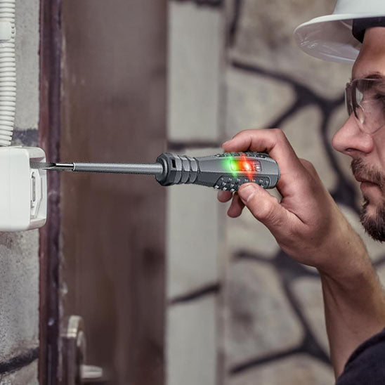 homme portant des lunettes teste une prise electrique avec Tournevis stylo électrique