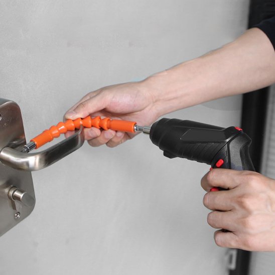 Homme tiens Tournevis electrique avec rallonge orange pour visser la poignée de la porte