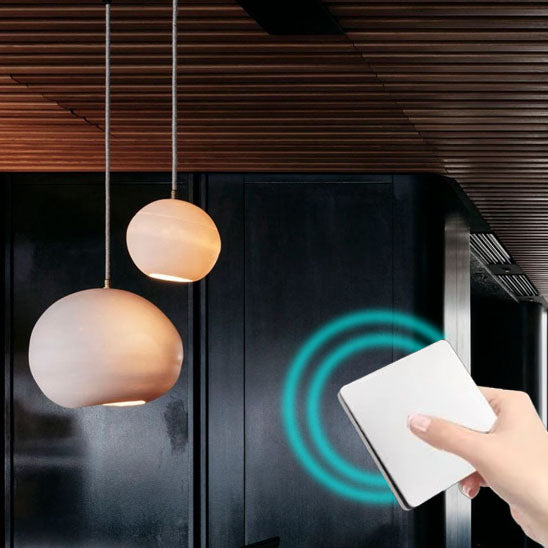 main de femmes appui sur Interrupteur connecté sans fil ,blanc ,deux plafonniers pendants brillent