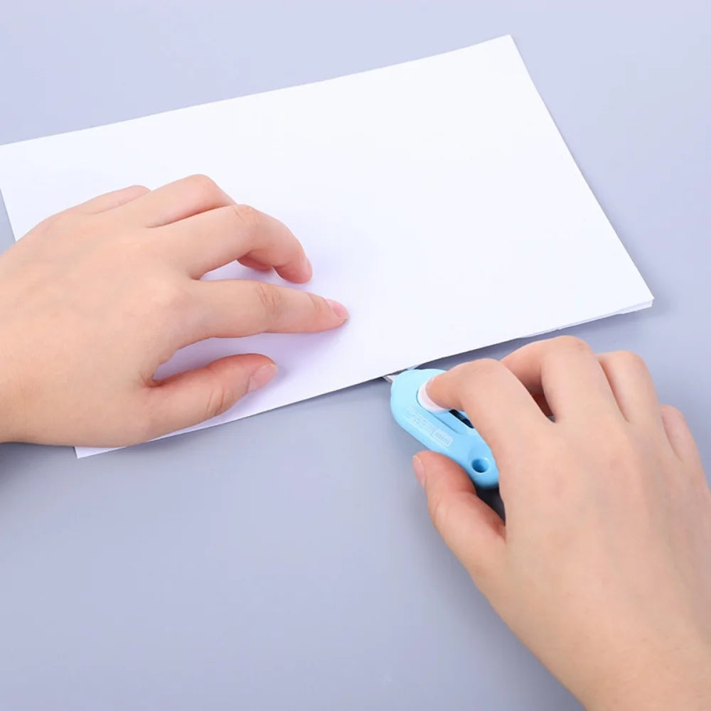 Main ouvre enveloppe blanche avec cutter bleu