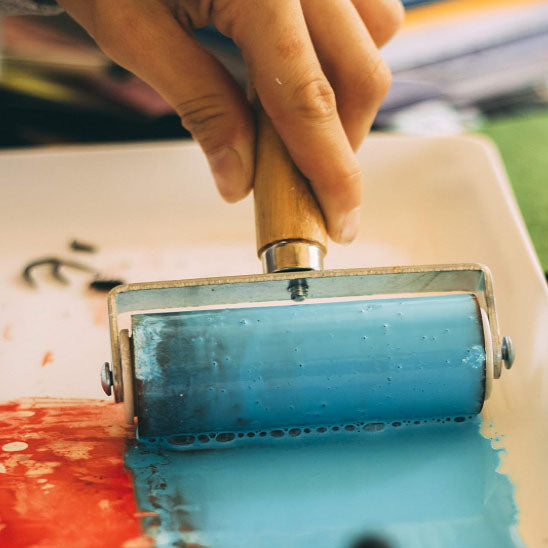 main tiens Rouleau peinture bleue