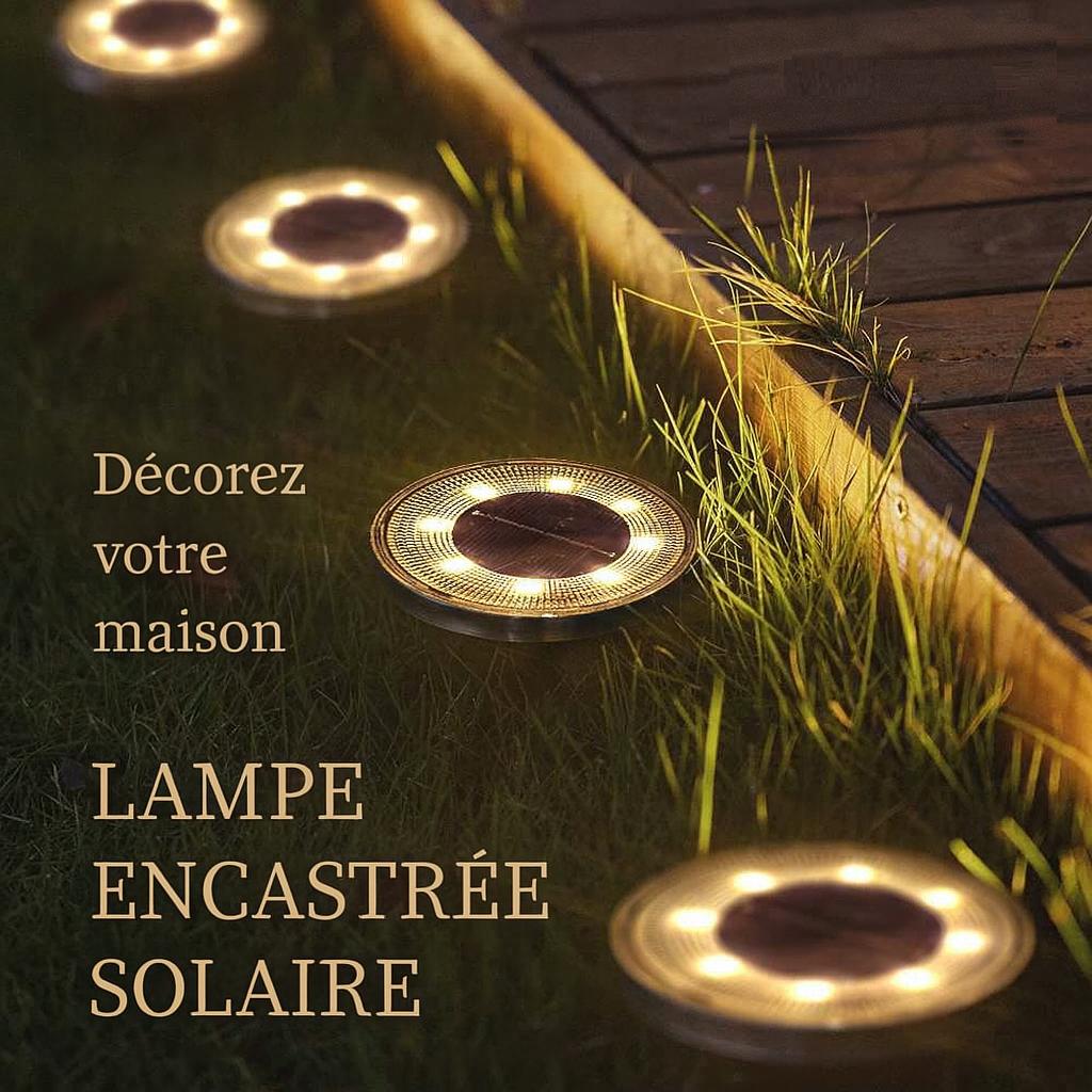 Quatre Lampe solaire exterieur allumées sur une allée de jardin en bois sur gazon