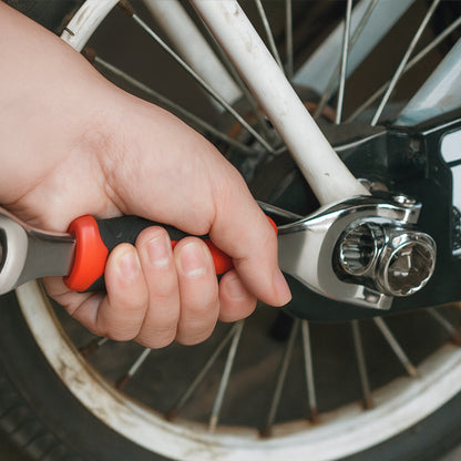 CLE A douilles dans une main qui serre un boulon de la fourche de roue de moto