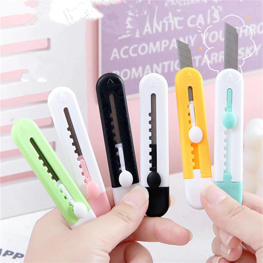 Cinq mini cutter animal ,vert blancs , noir et  jaune tenus par deux mains