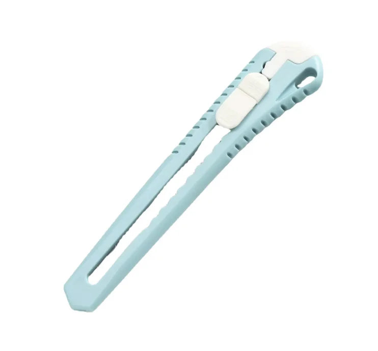 Cutter professionel bleu clair sur table blanche