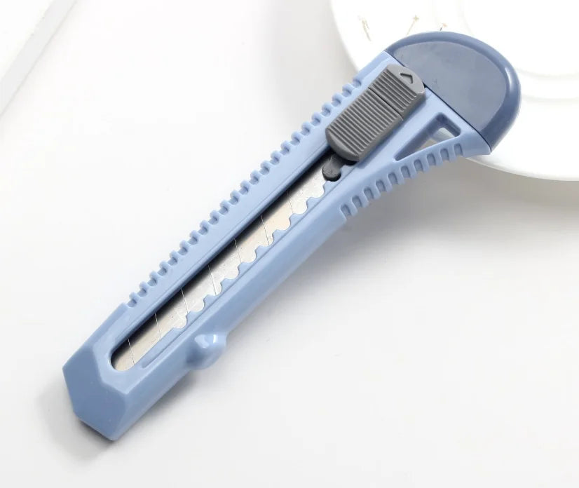 Cutter professionel bleu sur table blanche