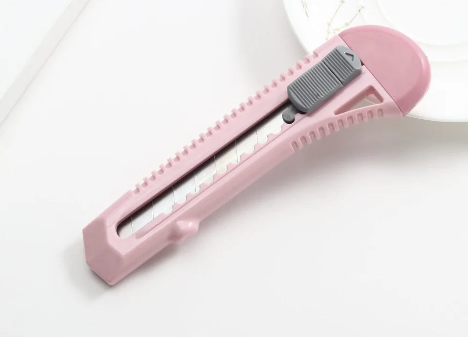 Cutter professionel rose sur table blanche