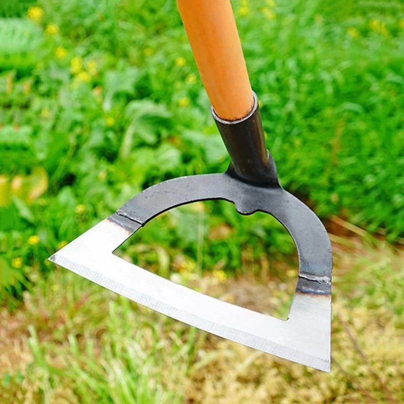 Houe creuse manche bois dans jardin vert