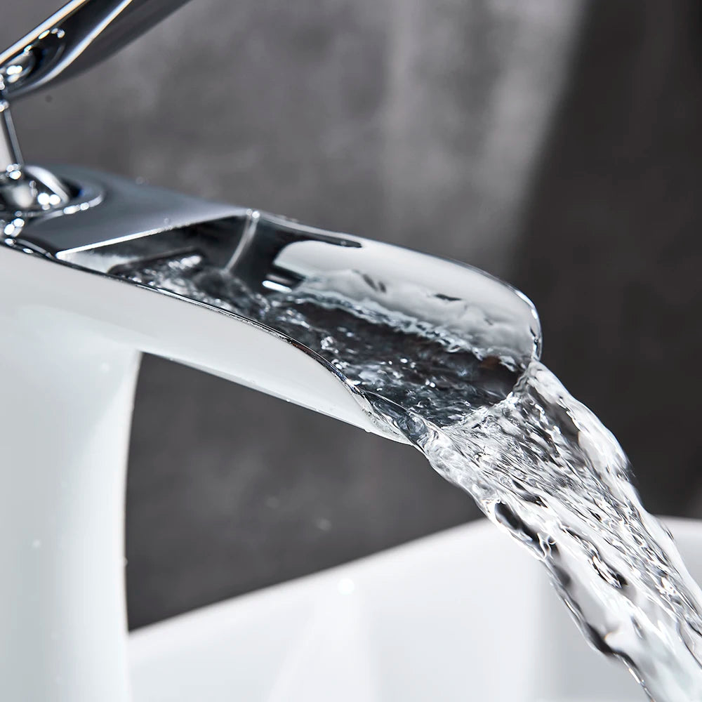 Robinet salle de bain cascade argenté eau limpide coule dans lavabo blanc 