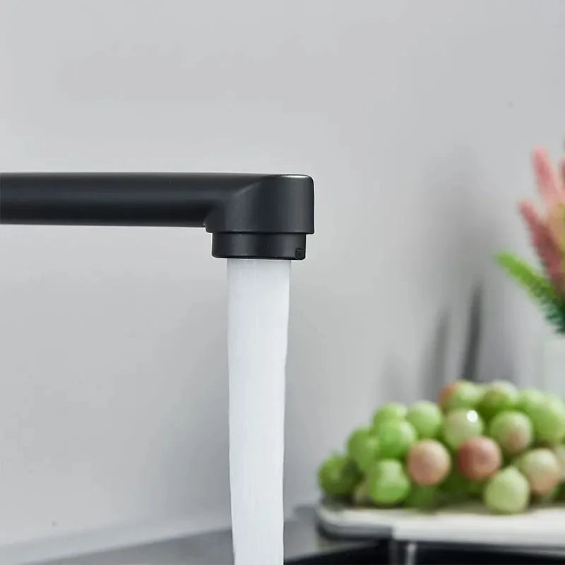 Eau du Robinet de cuisine noir coule dans l'évier, pommes vertes sur l'évier