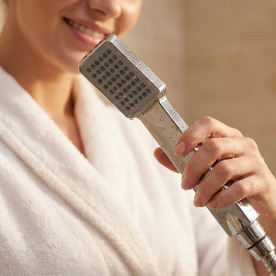 femme souriante peignoir blanc tiens Pommeau de douche blanc