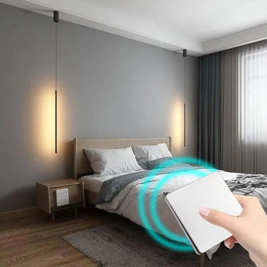 main de femme appui sur  Interrupteur connecté sans fil ,blanc devant le lit, appliques allumées  dans la chambre à coucher , 