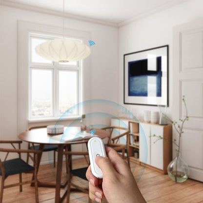 main appuyant sur interrupteur connecte blanc dans le salon , commande éclairage.
