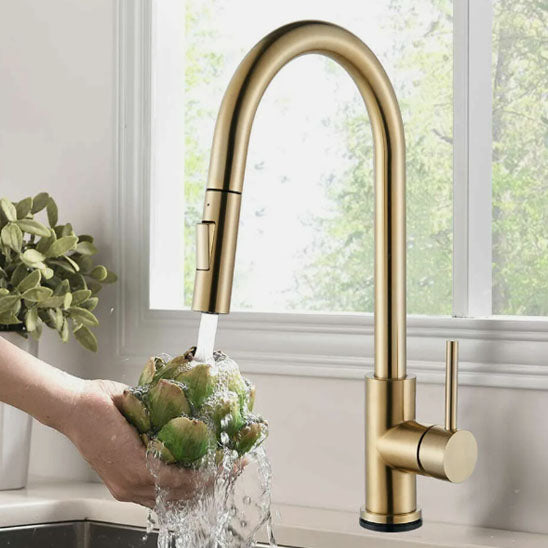 Main de femme lave un artichaut avec le Robinet cuisine doré extractible