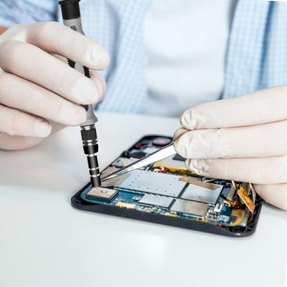 main d'un homme tient Tournevis 115 en 1  et repare smartphone 