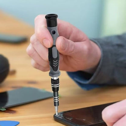 main d'un homme tient Tournevis 115 en 1  et repare smartphone