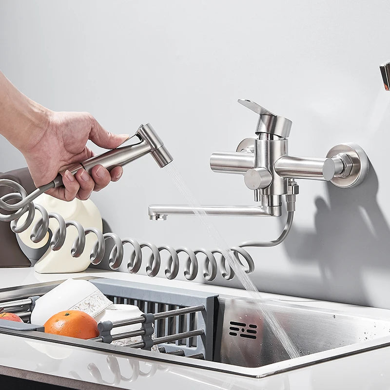 Main lave avec douchette du Robinet de cuisine nickel en mode jet d'eau la vaisselle dans l'évier
