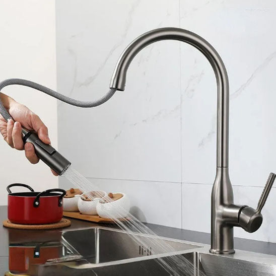 Main d'homme lave évier avec jet d'eau du Robinet cuisine doré à côté marmite rouge 