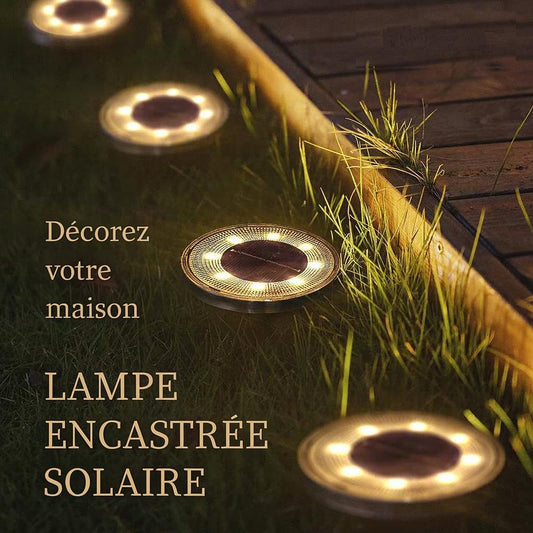 Quatre Lampe solaire exterieur allumées sur une allée de jardin en bois sur gazon