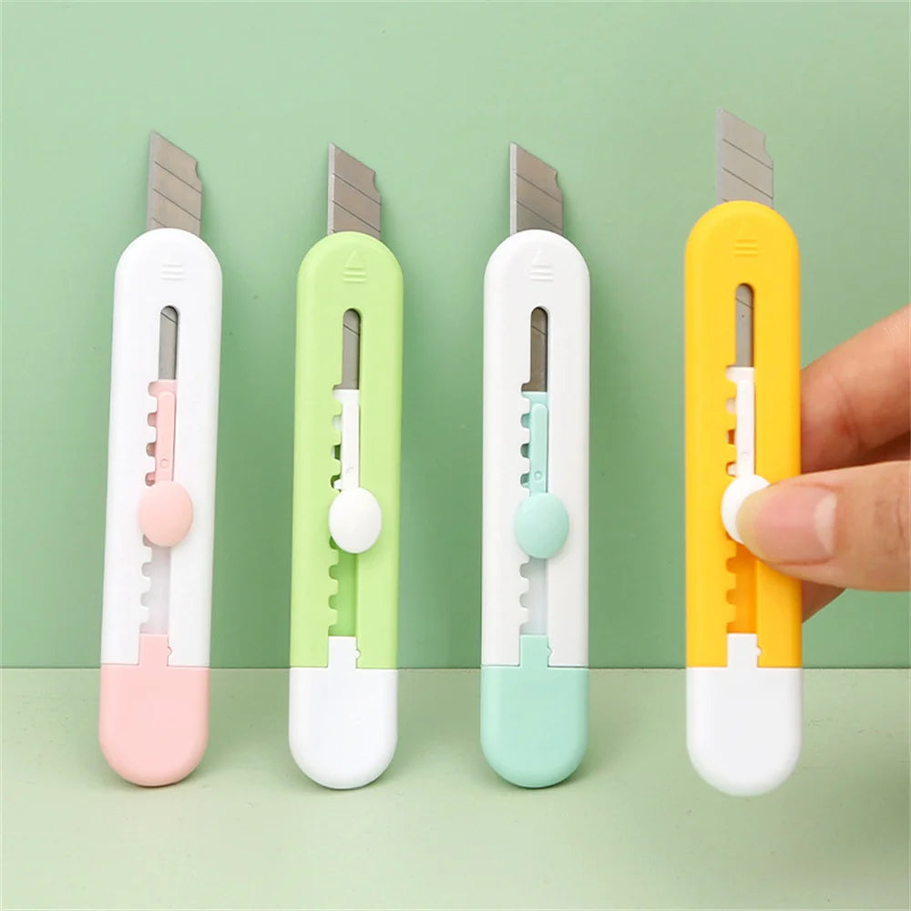 Quatre mini cutter animal ,vert blancs , noir et jaune tenus par une main