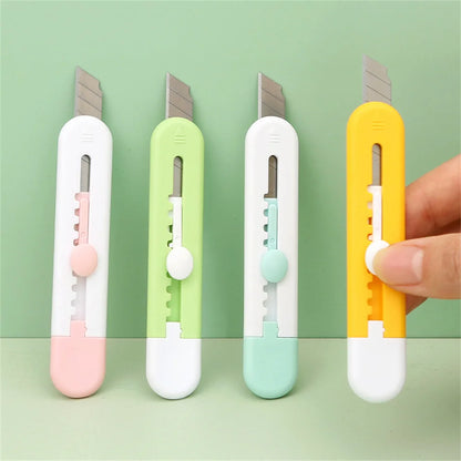 Quatre mini cutter animal ,vert blancs , noir et jaune tenus par une main